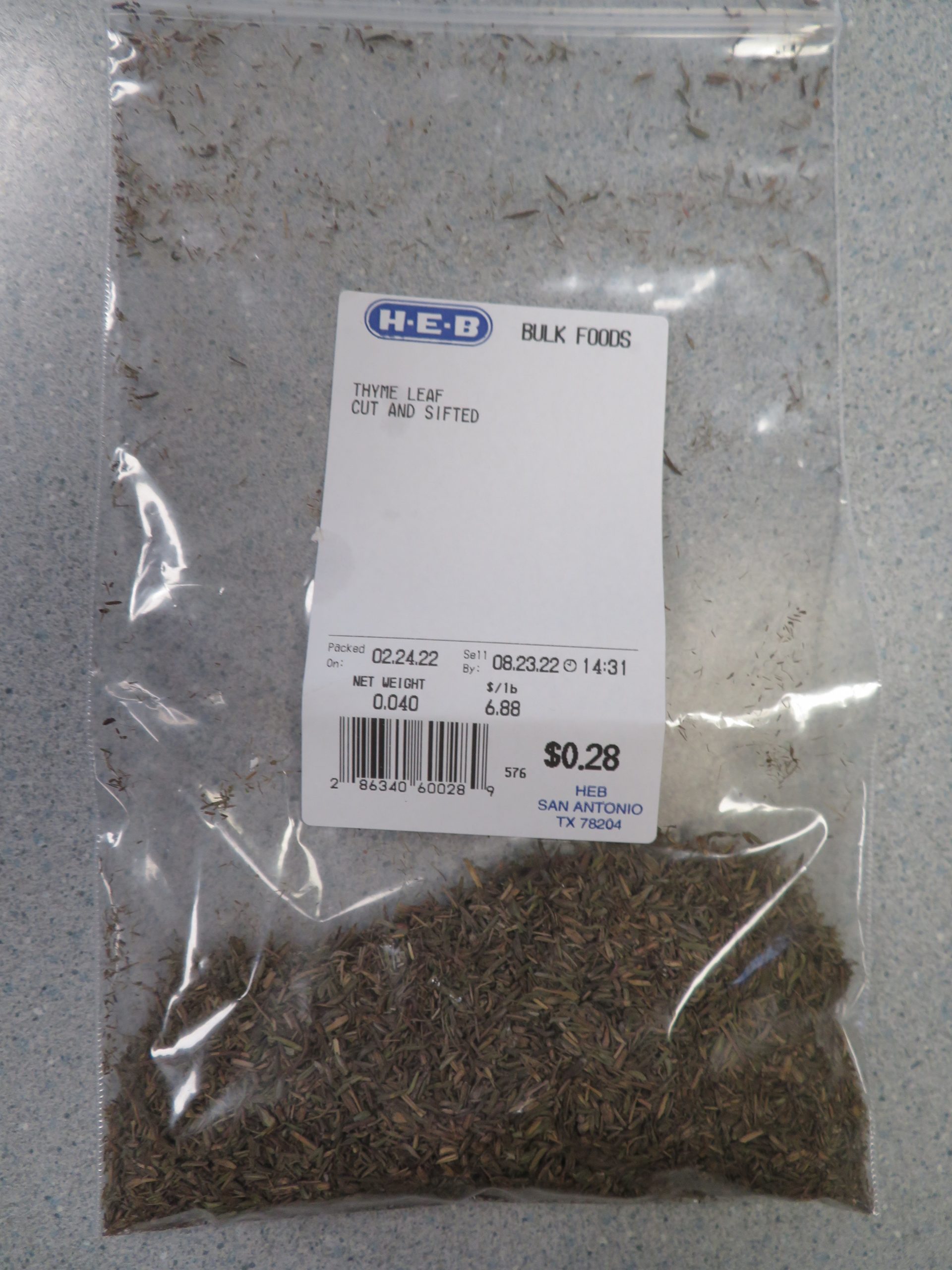 Small bag of dried leaf thyme showing price per pound and cost of the amount purchased