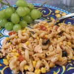 Amazing Tex-Mex Pasta Salad on a blue patterned plate with grapes