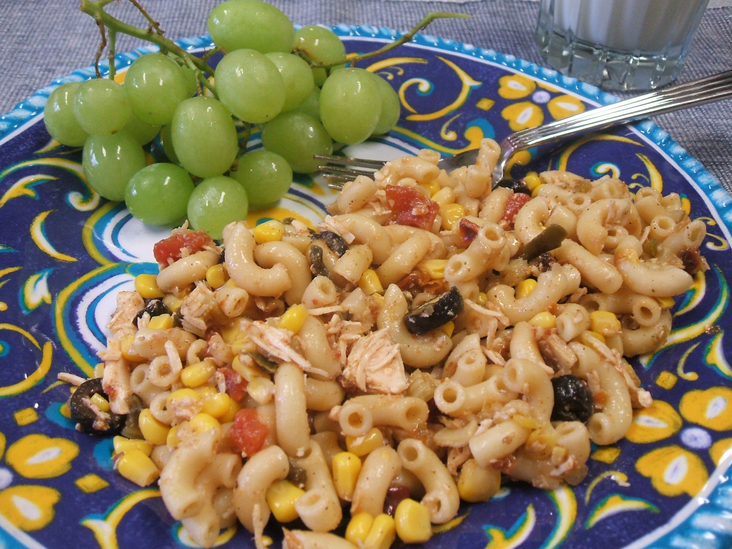 Amazing Tex-Mex Pasta Salad on a blue patterned plate with grapes