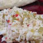 Green chile rice on a red plate