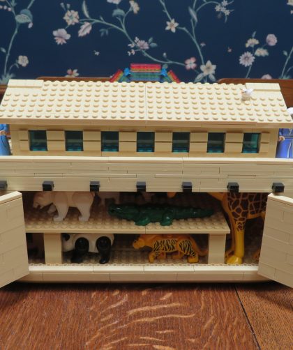 Open "Lego" ark with animals inside and people on deck.