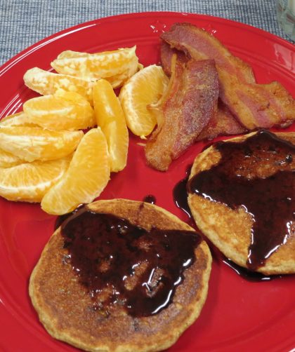 Multigrain Pancakes on a plate with bacon and orange slices