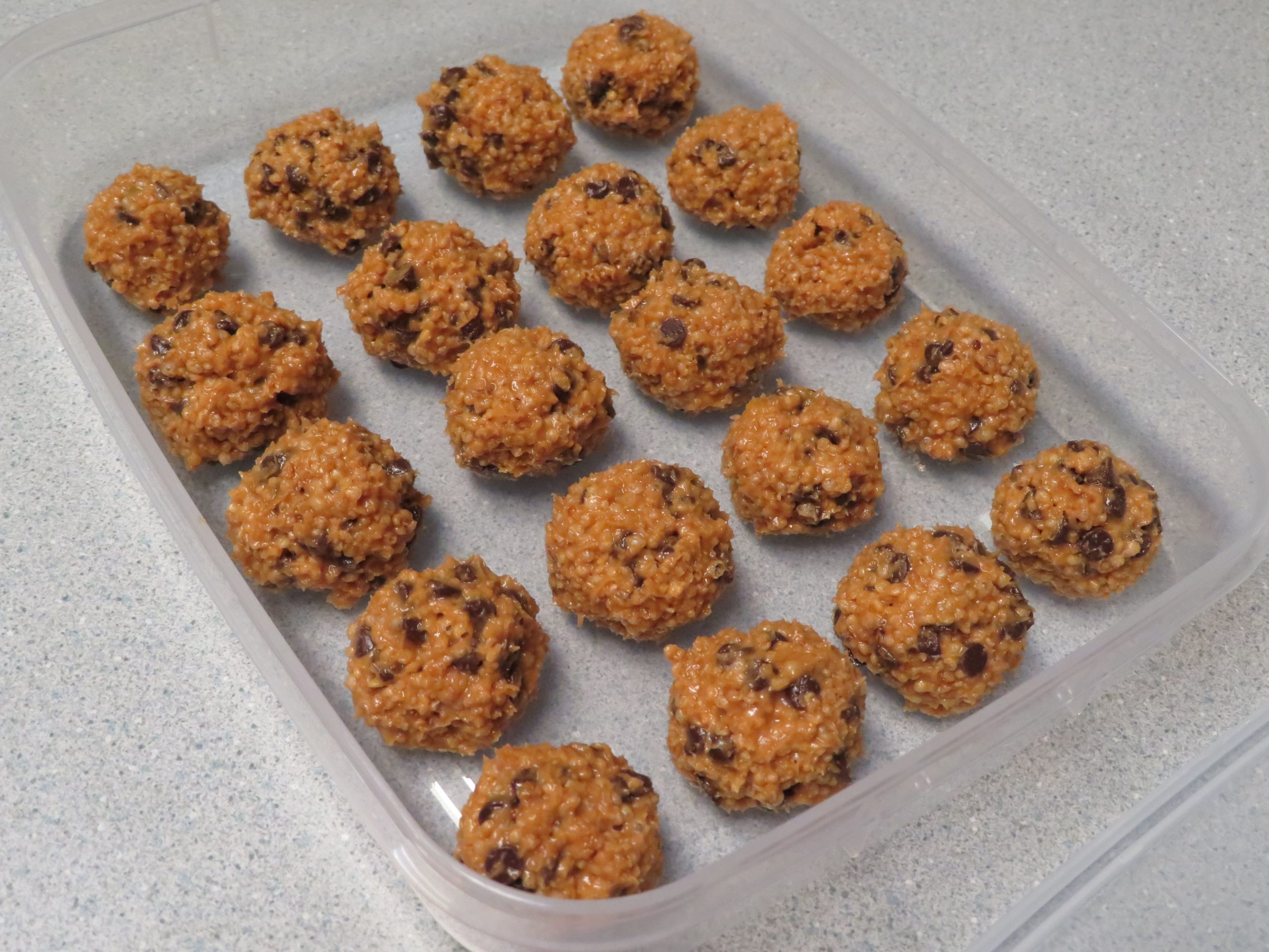 Crispy Quinoa Peanut Butter Balls in a clear plastic container