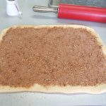 Cinnamon brown sugar spread on dough for cinnamon rolls