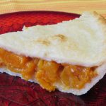 A slice of apricot pie on a plate